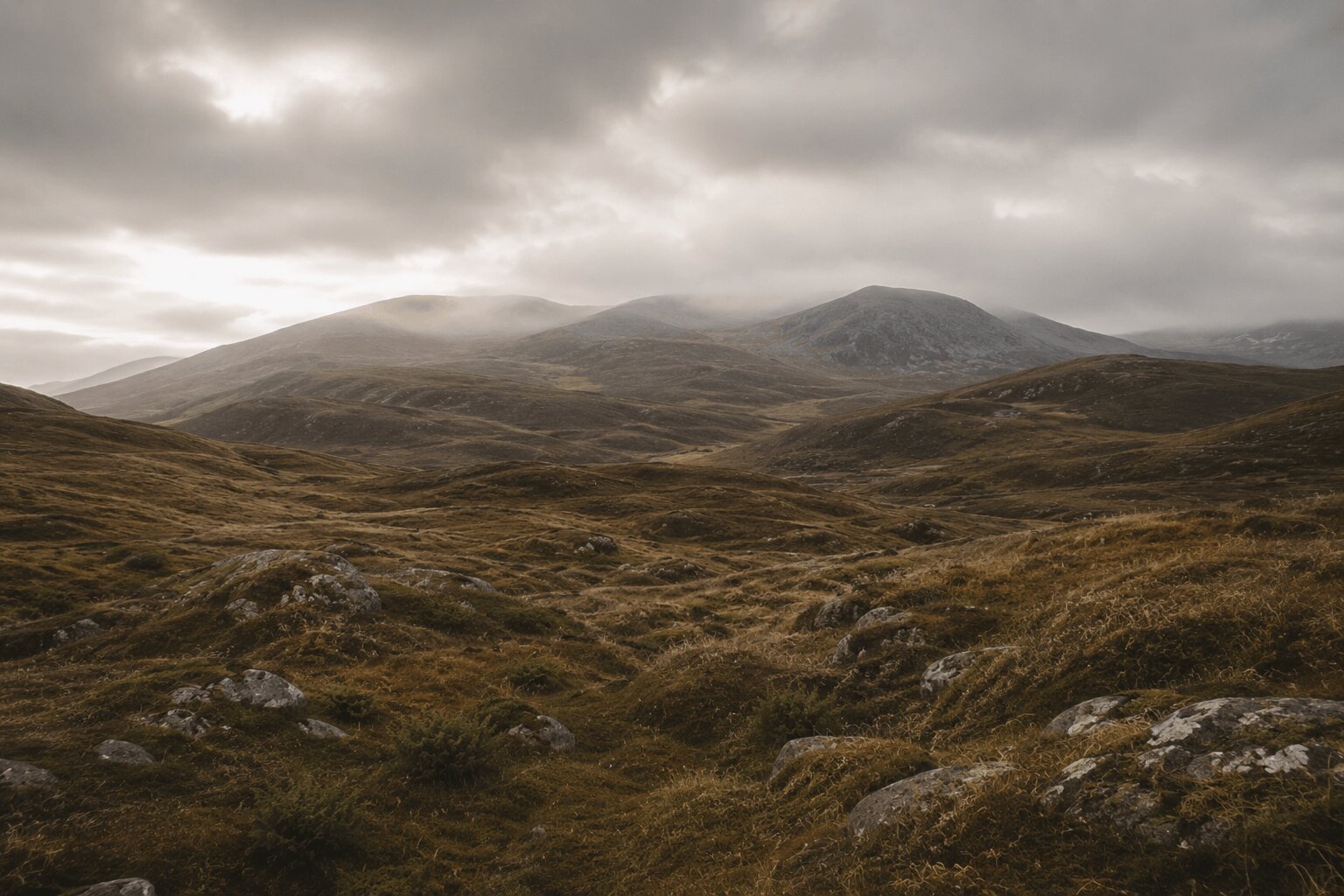 Peaceful Nordic rolling hills with earthy brown grasslands, soft green moss, mist-covered mountains, and dramatic overcast sky in rustic cinematic tones